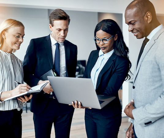 Professionals collaborating around a laptop